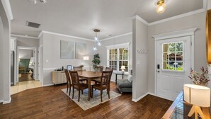 A dining area with a wooden table and chairs, a rug, and a piano. - Jacuzzi Tub-Walk to Dining & Shopping-Garage Parking (Tulsa)