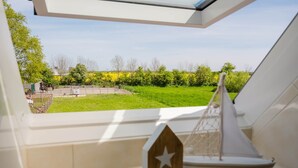 Vista desde una habitación con tragaluz, un objeto con forma de estrella de madera y un modelo de velero.