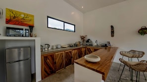 A modern kitchen with a wooden island, stainless steel appliances, and a large window. - Mamaya Rental Villa El Nido (El Nido)