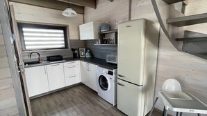 Eine kleine Küche mit Waschmaschine, Toaster und Kühlschrank.