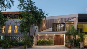 A modern two-story house with a wooden facade, large windows, and a well-lit entrance. - Villa Amalia, 5 bdr w/Private Pool in Aldea  Zama (Tulum)