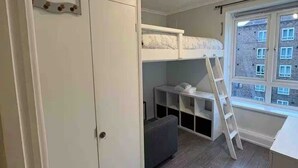 A compact room with a bunk bed, built-in wardrobe, and a window with a view of buildings. - Vauxhall Central Room 2 (Greater London)