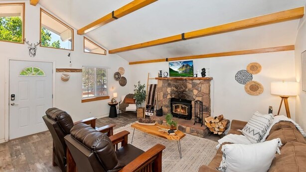 Ein gemütliches Wohnzimmer mit Kamin, Ledersofas und einem steinernen Kaminumrandung.
