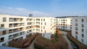 A modern apartment complex with multiple floors, balconies, and a central courtyard.