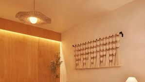 A modern living room with a sofa, a coffee table, a lamp, and a wall-mounted decorative piece.