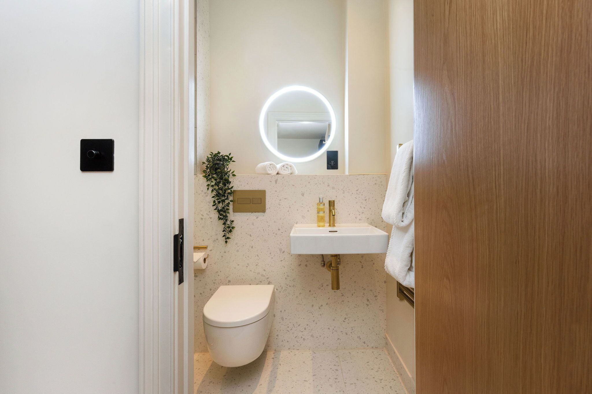 A small bathroom with a toilet, sink, and mirror.