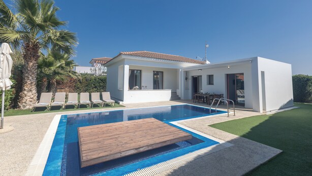 Une maison moderne dotée d’une piscine, d’une terrasse en bois et d’un espace patio.