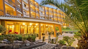 A multi-story hotel with outdoor seating and a landscaped garden. - Apartment in Tossa de Mar for 4 People (Tossa de Mar)