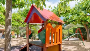 A playground with a slide, climbing structure, and a small bridge. - Apartment in Tossa de Mar for 4 People (Tossa de Mar)