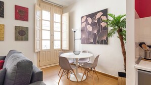Un comedor con una mesa redonda, cuatro sillas y una lámpara de pie.