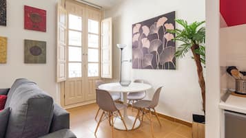 Un comedor con una mesa redonda, cuatro sillas y una lámpara de pie.