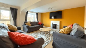 Ein modernes Wohnzimmer mit zwei grauen Sofas, einem kleinen runden Couchtisch und einem Kamin.