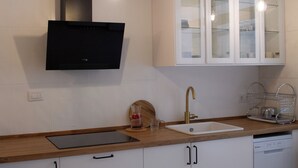 A modern kitchen with a built-in oven, a sink, and a wooden countertop.