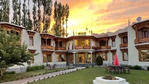 Ein Hotel mit Innenhof, Außenbereich und Blick auf den Sonnenuntergang.