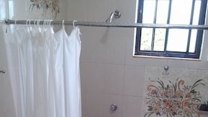 Un baño con ducha, inodoro y lavabo.