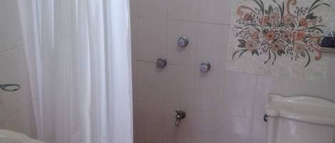 A bathroom with a shower, toilet, and sink.