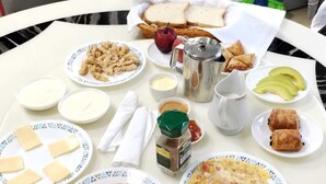 A breakfast table with various food items including toast, eggs, and pastries. - Charming 2-bedroom villa with WiFi and AC in Grand Baie (Grand Baie)