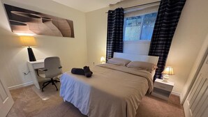 Ein Schlafzimmer mit einem Bett, einem Schreibtisch und einem Stuhl.