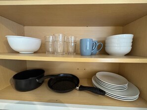 Un estante de cocina con varios platos y utensilios de cocina.