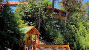 A playground with a slide, swings, and a small wooden structure.