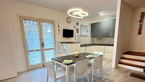 A modern kitchen with grey cabinets, a black countertop, and a built-in oven. - Modern two Level Villa With Playground and Pool (San Michele al Tagliamento)