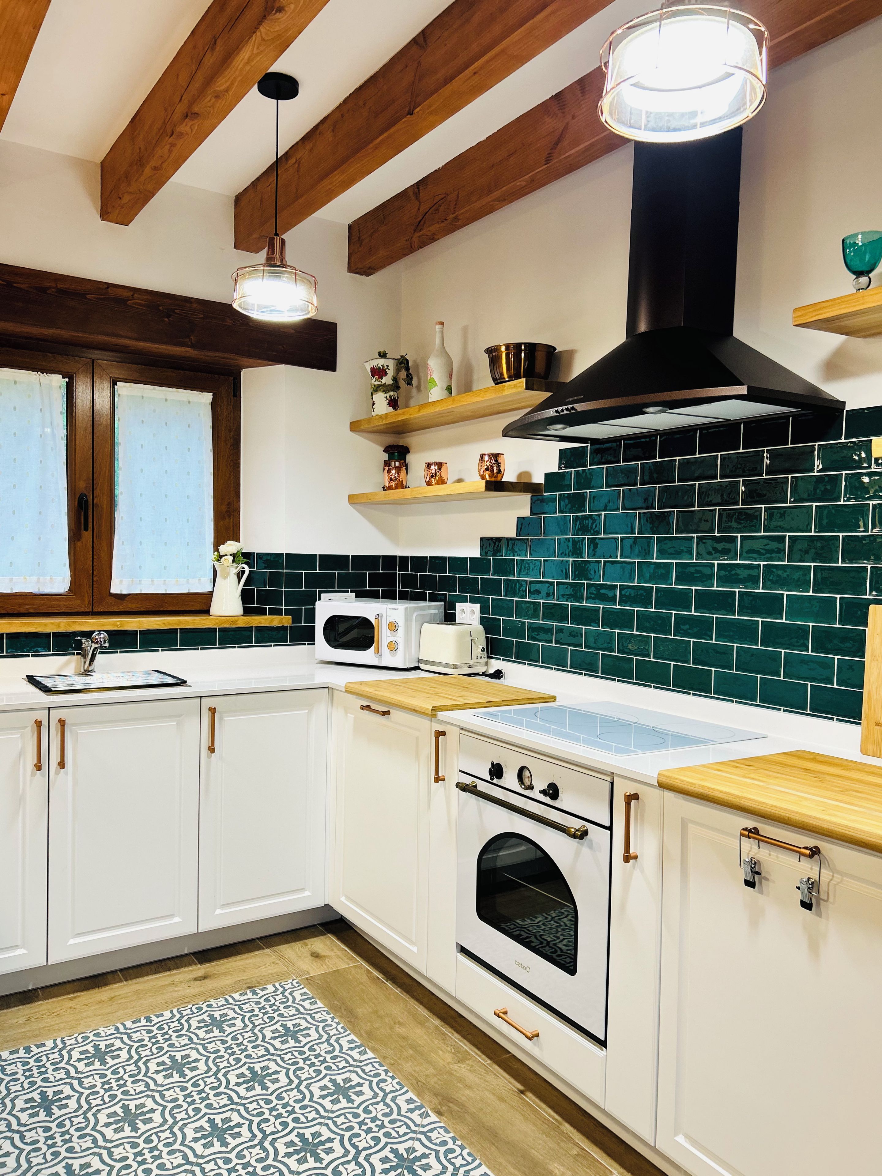 A kitchen with white cabinets, a black stove, a microwave, and a wooden countertop.