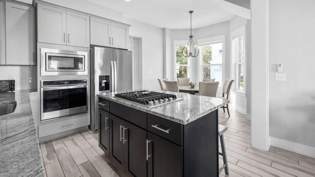 A modern kitchen with stainless steel appliances, a marble countertop, and a dining area with a view. - 🦩Book Me Baby! Seas The Day at Inlet Beach🦩 (Inlet Beach)
