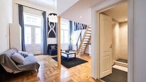 Ein modernes Wohnzimmer mit einer Couch, einem Couchtisch und einer Treppe, die zu einem Erker führt.