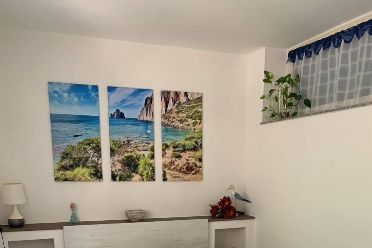 Ein Schlafzimmer mit einem Bett, zwei Nachttischen, einer Lampe und einem Fenster mit Blick auf Klippen und das Meer.