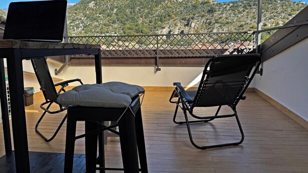 A balcony with a table and two chairs, overlooking a mountainous landscape. - Attic with terrace and nice view! (Sora)