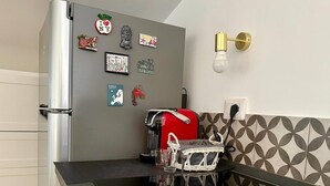 A kitchen with a refrigerator, a coffee machine, and a wall-mounted light fixture. - Attic with terrace and nice view! (Sora)