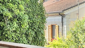 Un bâtiment doté d’une façade en pierre, d’un toit en tuiles et d’une porte en bois.