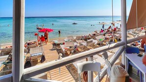 Un restaurante frente a la playa con terraza y vistas al mar.