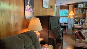 A cozy living room with a comfortable sofa, a television, a lamp, and a bookshelf.