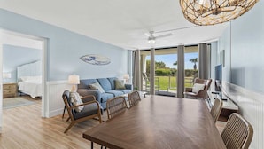 A spacious room with a large dining table, a sofa, and a ceiling fan. - Oceanfront I Resort-Style I Heated Pool I Beach (Cape Canaveral)