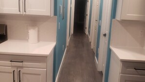 Una cocina con armarios blancos y piso de madera.