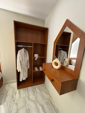 A bathroom with a wooden vanity, a mirror, and a robe rack. - Hermes &Pyramids Hotel (Giza)