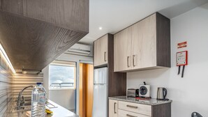 Eine moderne Küche mit Edelstahlgeräten, Holzschränken und Blick zum Himmel.