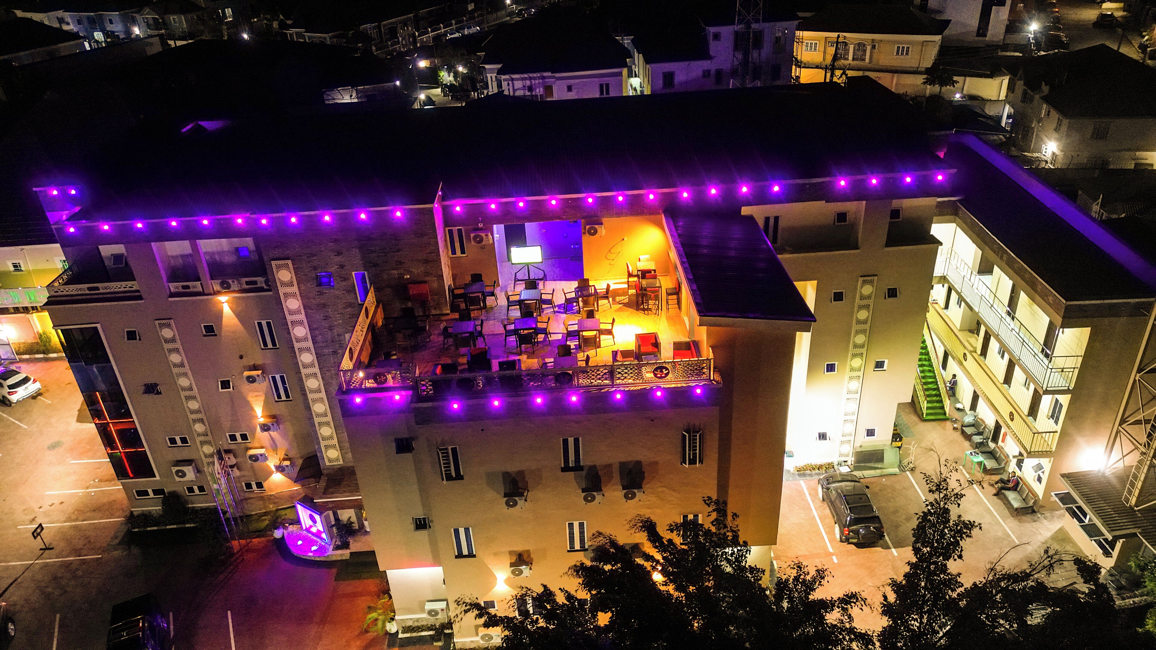 Vista aérea de un hotel con varios pisos, zonas de estar al aire libre y un patio central con una fuente.