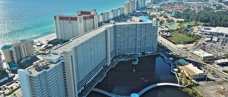 A large hotel with multiple high-rise buildings, a marina, and a view of the ocean.