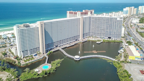 Un hotel grande con varios edificios altos, un puerto deportivo y una masa de agua.