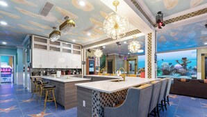 Une cuisine moderne dotée d’un îlot central, d’un bar et d’un grand mur décoré d’un aquarium.