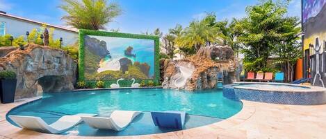 Een buitenzwembad en ligstoelen