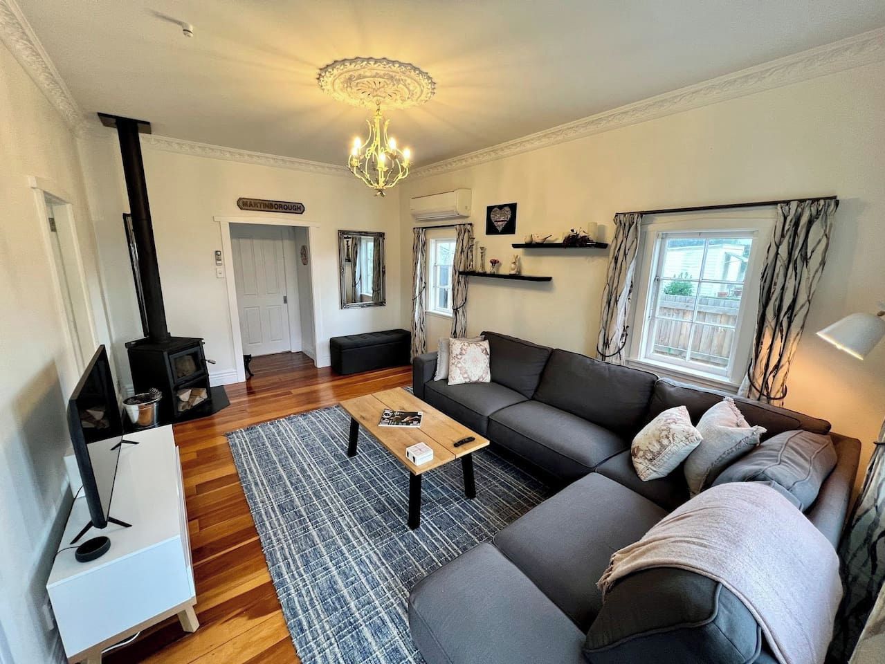 A living room with a sofa, coffee table, and a fireplace.