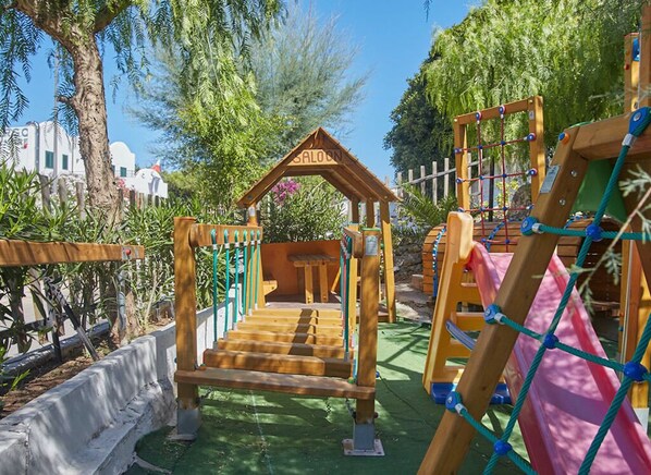 Children can play and climb in this outdoor play area featuring a climbing structure with a roofed entrance, rope net, and slide.