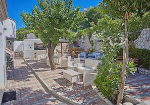 Relax in style on this beautifully landscaped patio, surrounded by lush greenery and comfortable seating.
