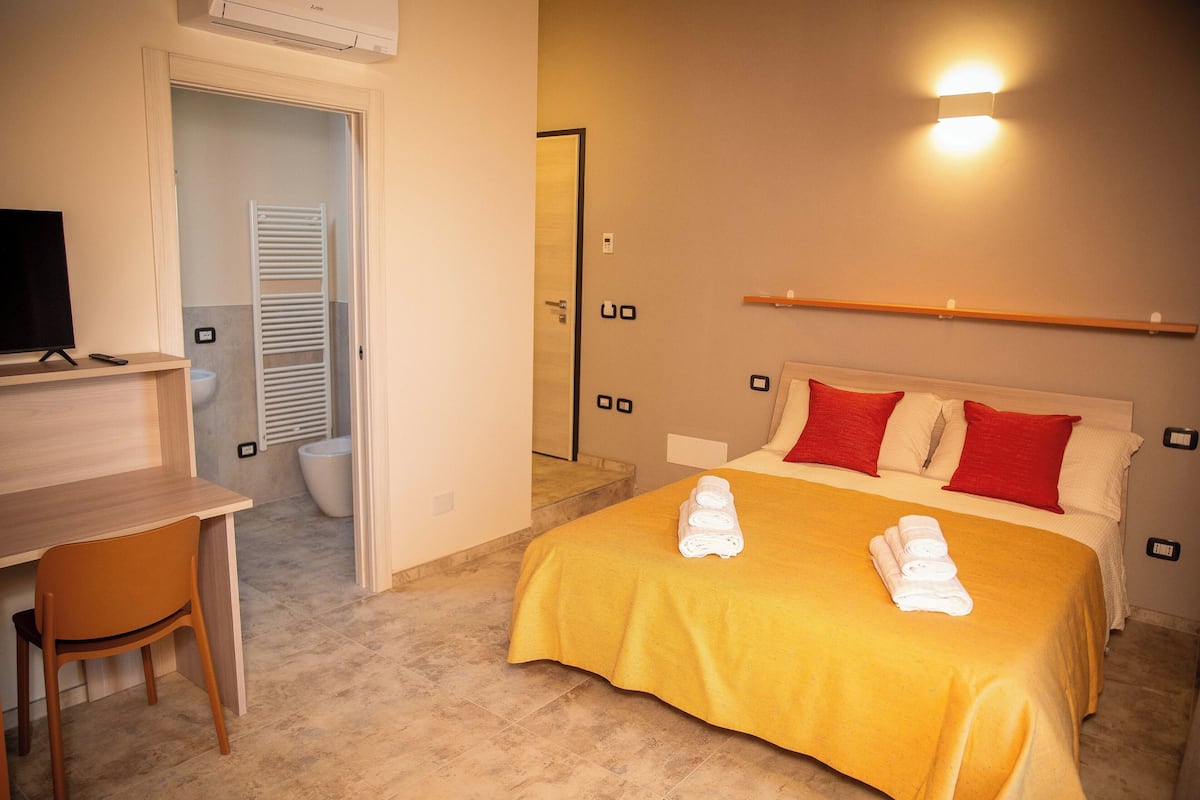 Una habitación de hotel con una cama, un escritorio y un televisor.