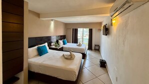 A hotel room with two beds, a nightstand, a lamp, and an air conditioning unit. - AMANÁA Hotel Boutique (Playa del Carmen)