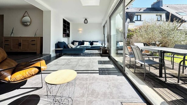 Una sala de estar moderna con un sofá, una mesa de centro y un comedor con sillas y una mesa.