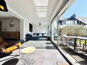 Una sala de estar moderna con un sofá, una mesa de centro y un comedor con sillas y una mesa.